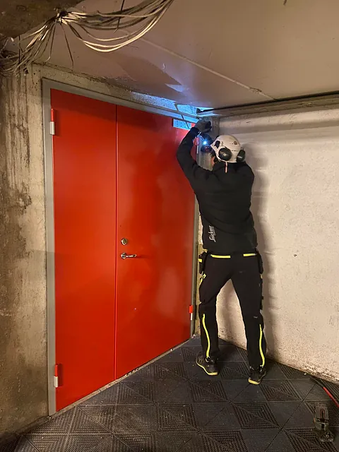 Nærbilde av gravemaskinskuffe som graver i sand og jord.